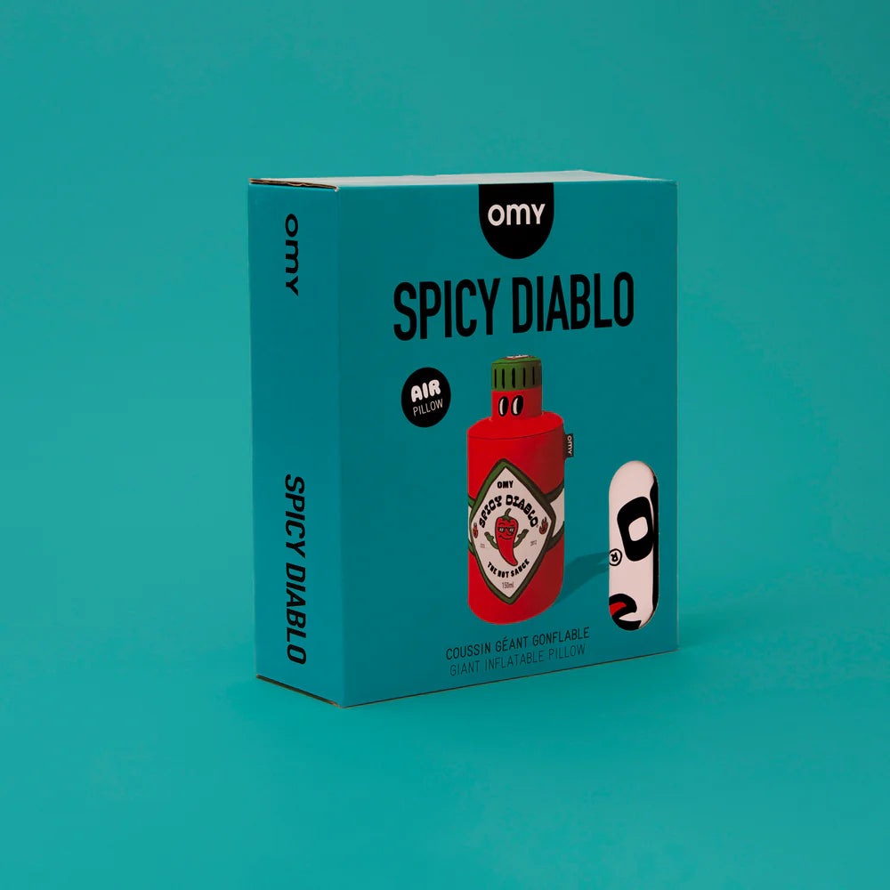 OMY Spicy Diablo giant inflatable pillow in turquoise packaging with bold black typography and a red bottle graphic.