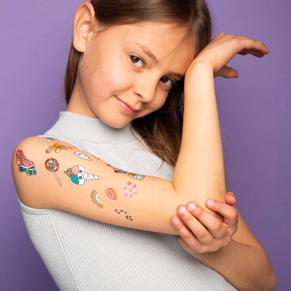 OMY Unicorn Tattoos on a smiling girl's arm, showing colorful unicorn-themed temporary stickers.