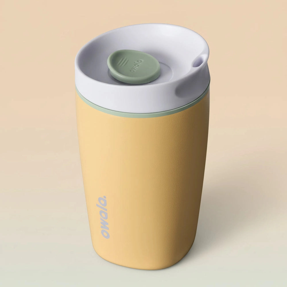 Yellow tumbler with a white lid and green base on a white background
