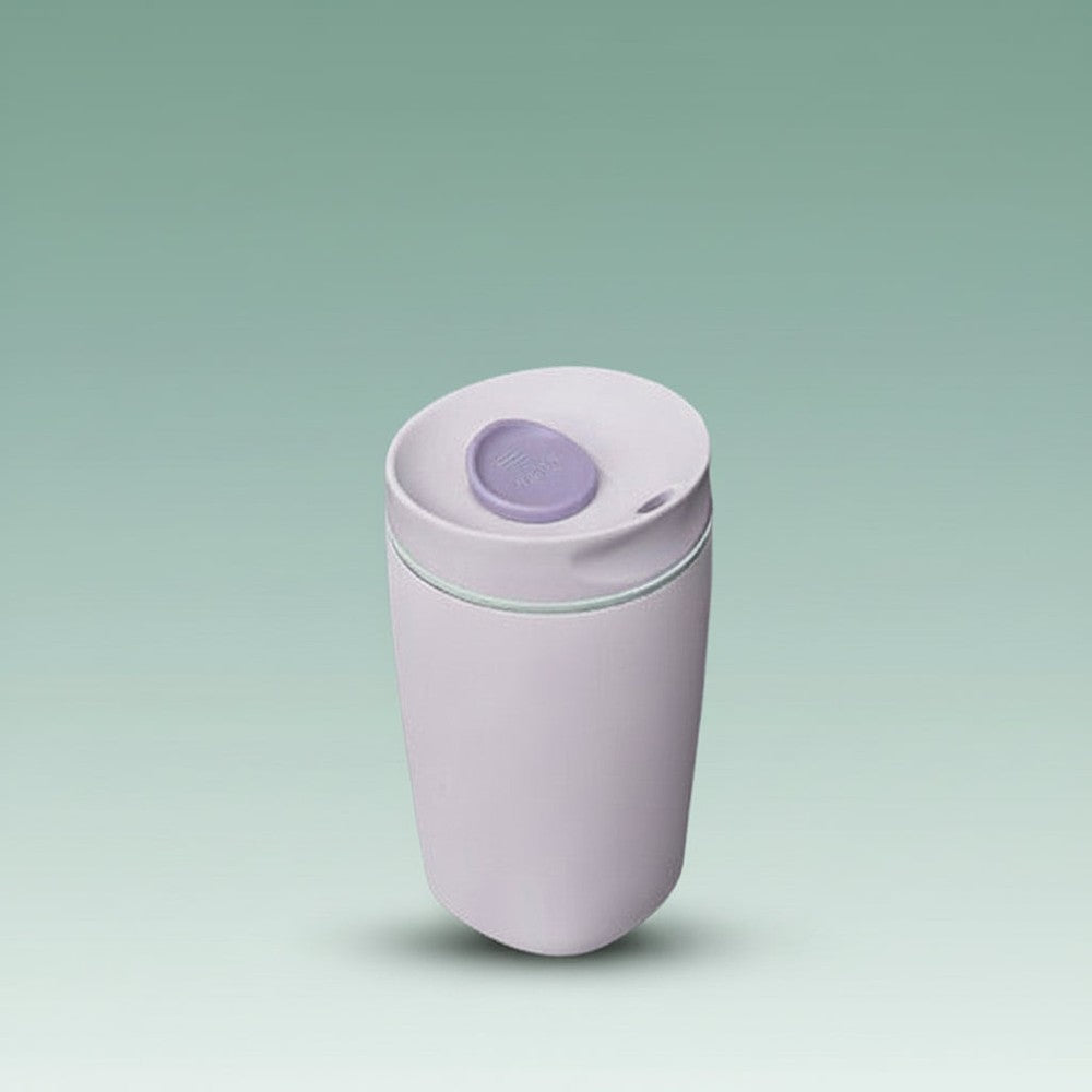 White tumbler with a purple lid on a white background