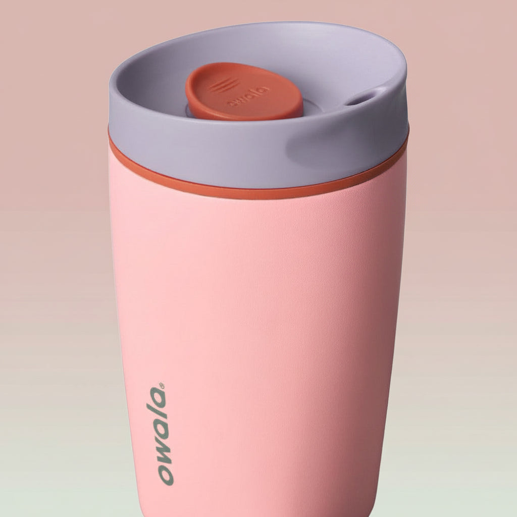 Pink travel mug with a gray lid on a white background