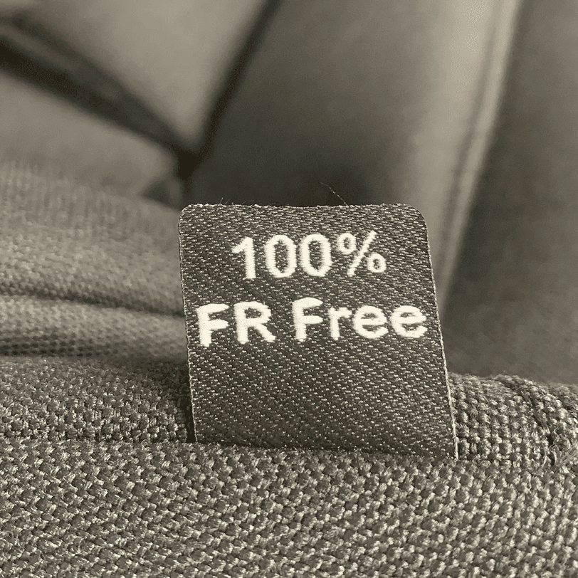 Peg Perego Viaggio Shuttle Booster Seat in dark fabric, tag reads 100% FR Free proving flame-retardant-free material.