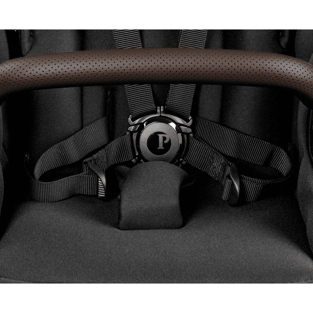 Peg Perego YPSI Stroller with perforated brown handlebar grip and secure harness straps.