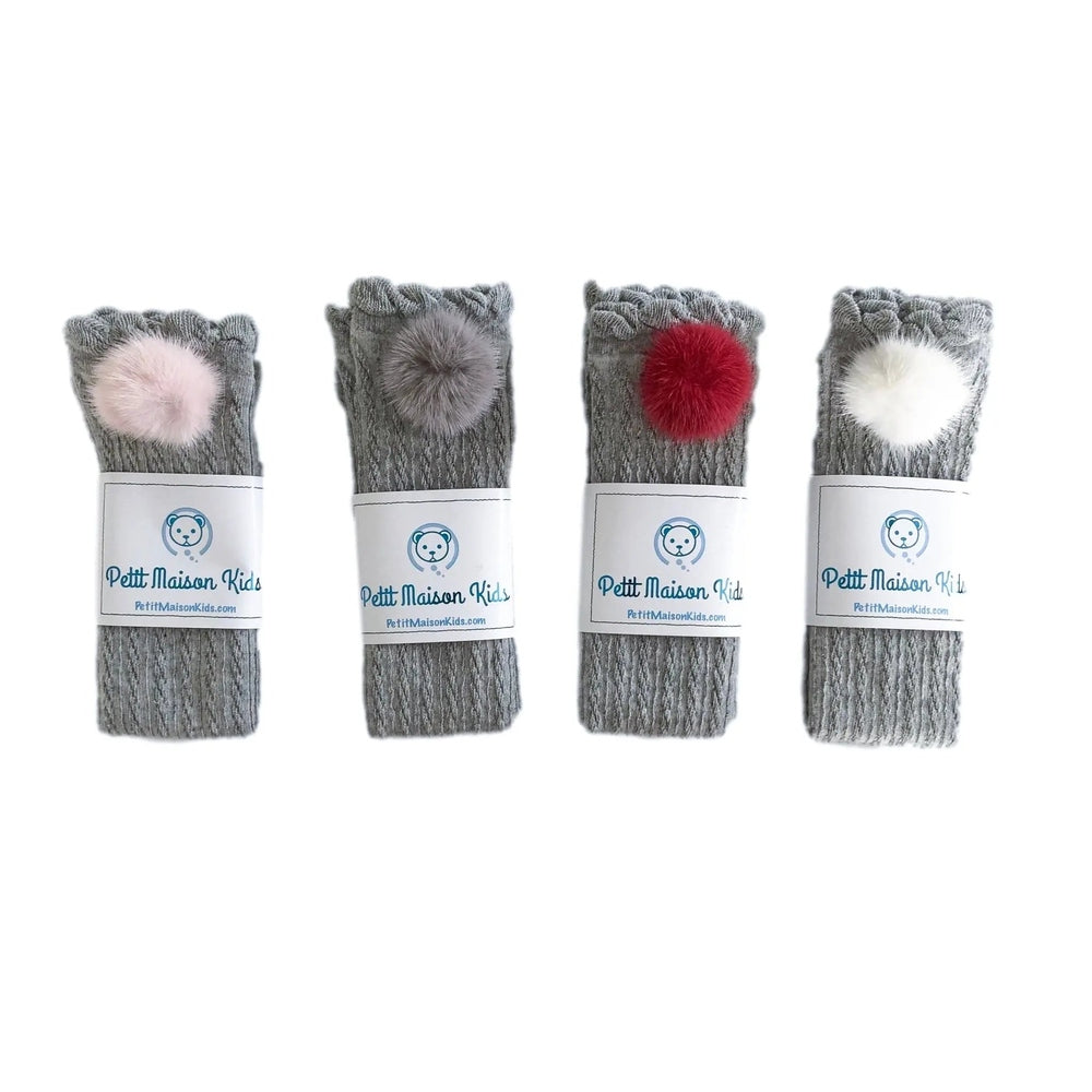 Petite Maison Kids Grey Knee High Socks With Poms, 4-pair set shown rolled with pink, grey, red and white fluffy pom poms.