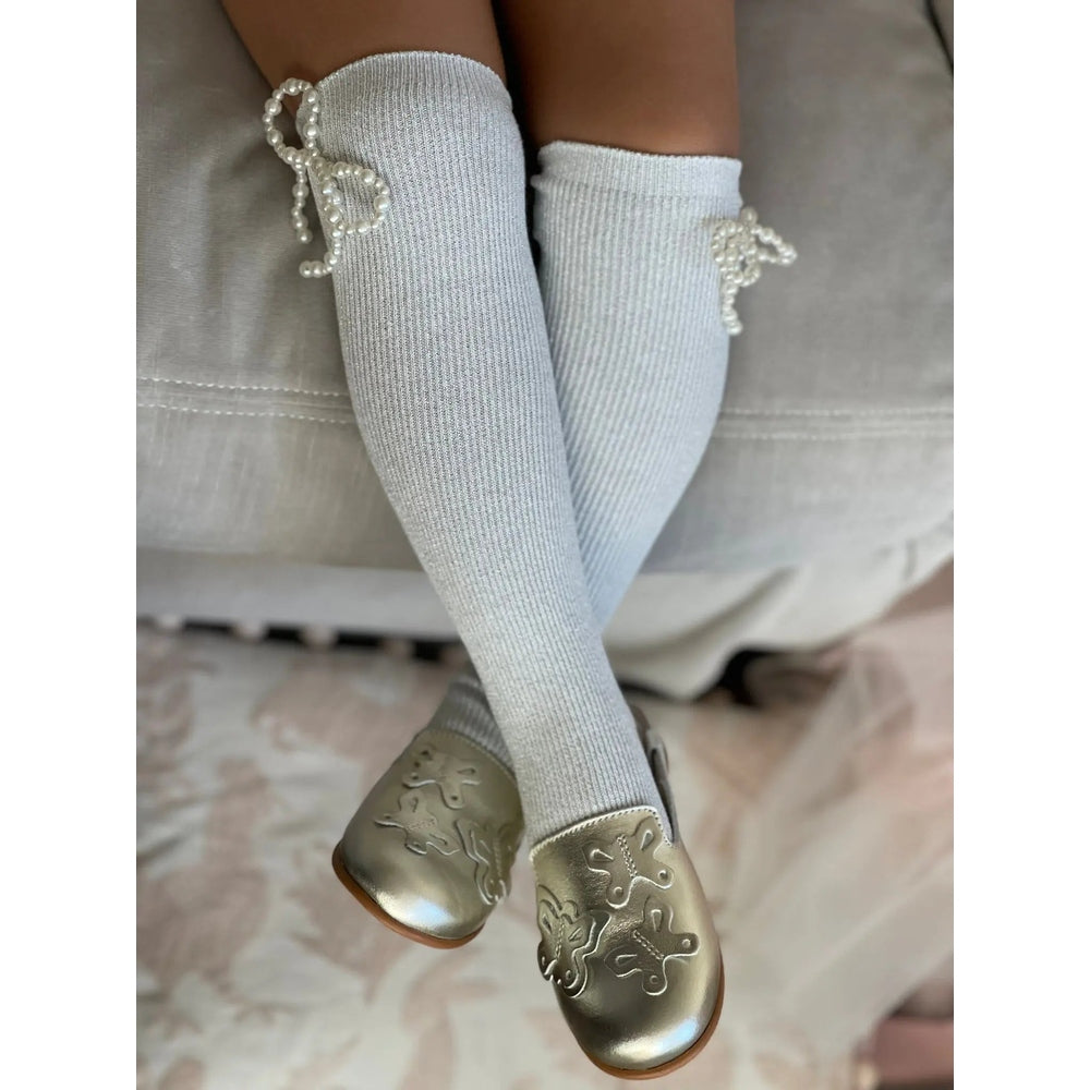 Petite Maison Kids Perla Shimmer Socks knee-high, light gray with pearl bows, worn on a child.
