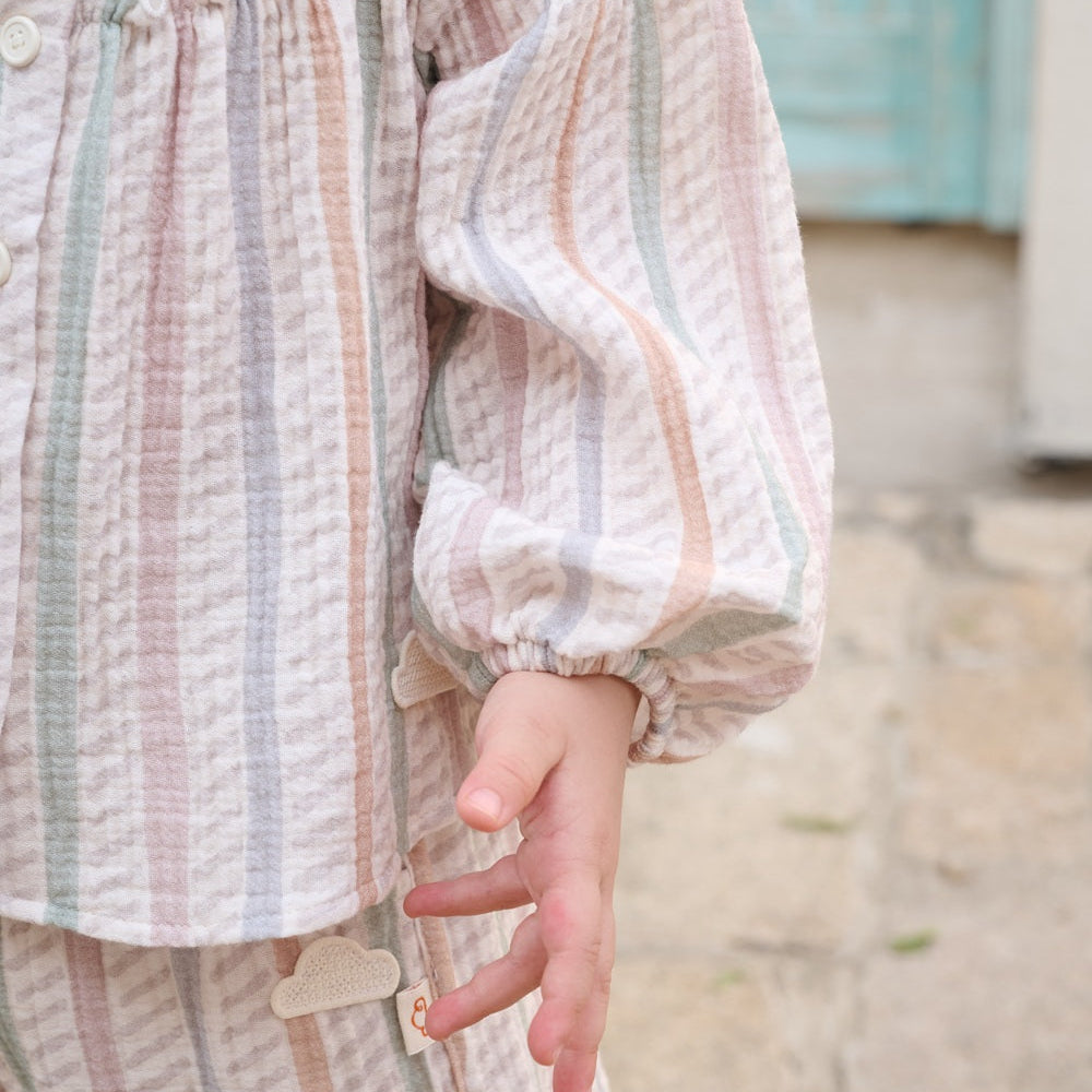 Close-up of a child wearing a striped outfit with a blurred background