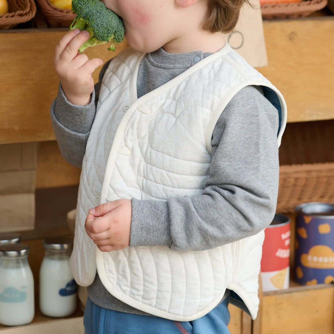 Petite Revery Oceanview Cloud reversible quilted vest worn cream-side out over a grey top