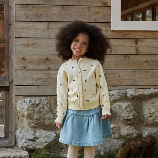 Petite Revery cotton knit cardigan in cream with tiny print, paired with a light blue denim skirt.