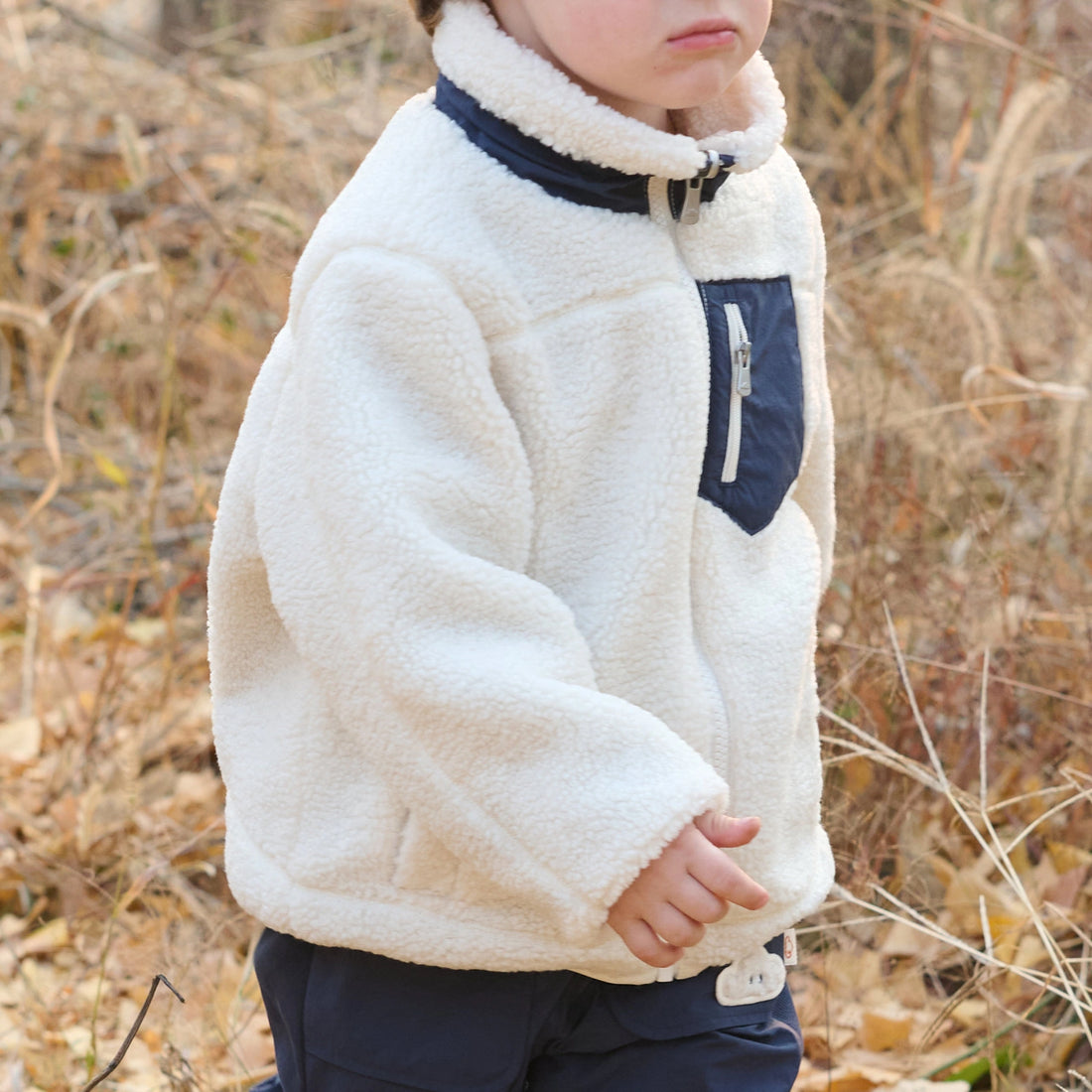 Petite Revery Cozy Crumbs Reversible Fleece Jacket in Blueberry, cream fleece side worn outdoors