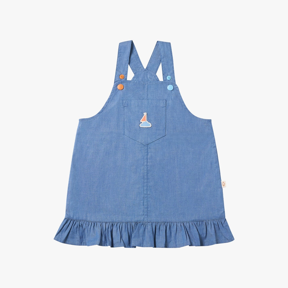 Petite Revery Denim Dress Overalls Sky blue with cross straps and ruffled hem, front pocket detail