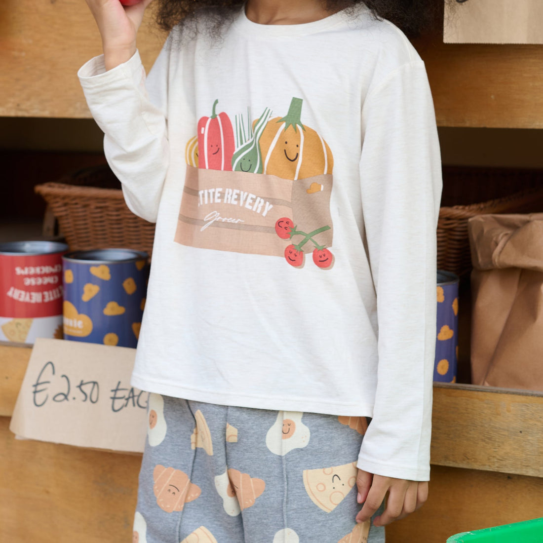 Petite Revery Sea Salt Munchies tee worn close-up showing the colourful grocery-bag print