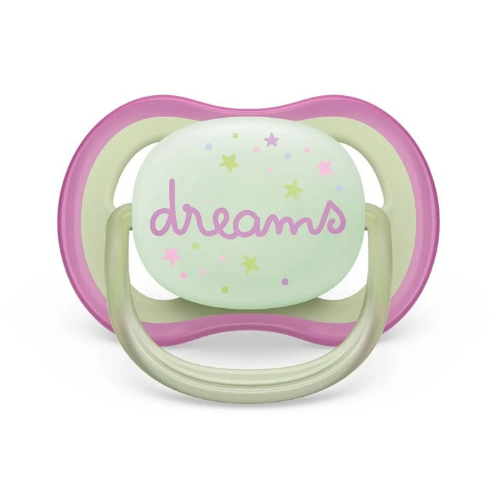 Mint green pacifier with pink outer rim and cream ring; shield features pastel stars and "dreams" text.