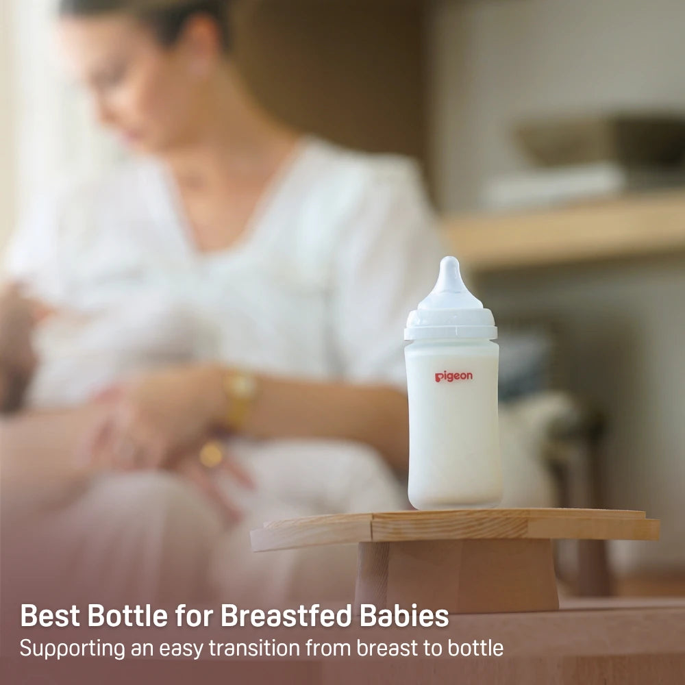 A Pigeon baby bottle on a table with a parent and baby in the background
