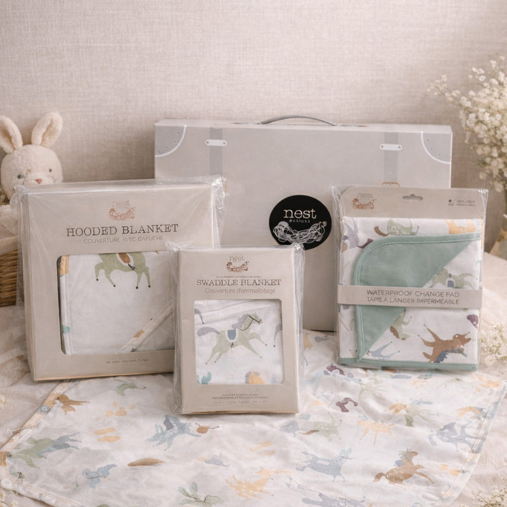 Baby products including hooded and swaddle blankets with packaging on a neutral background.