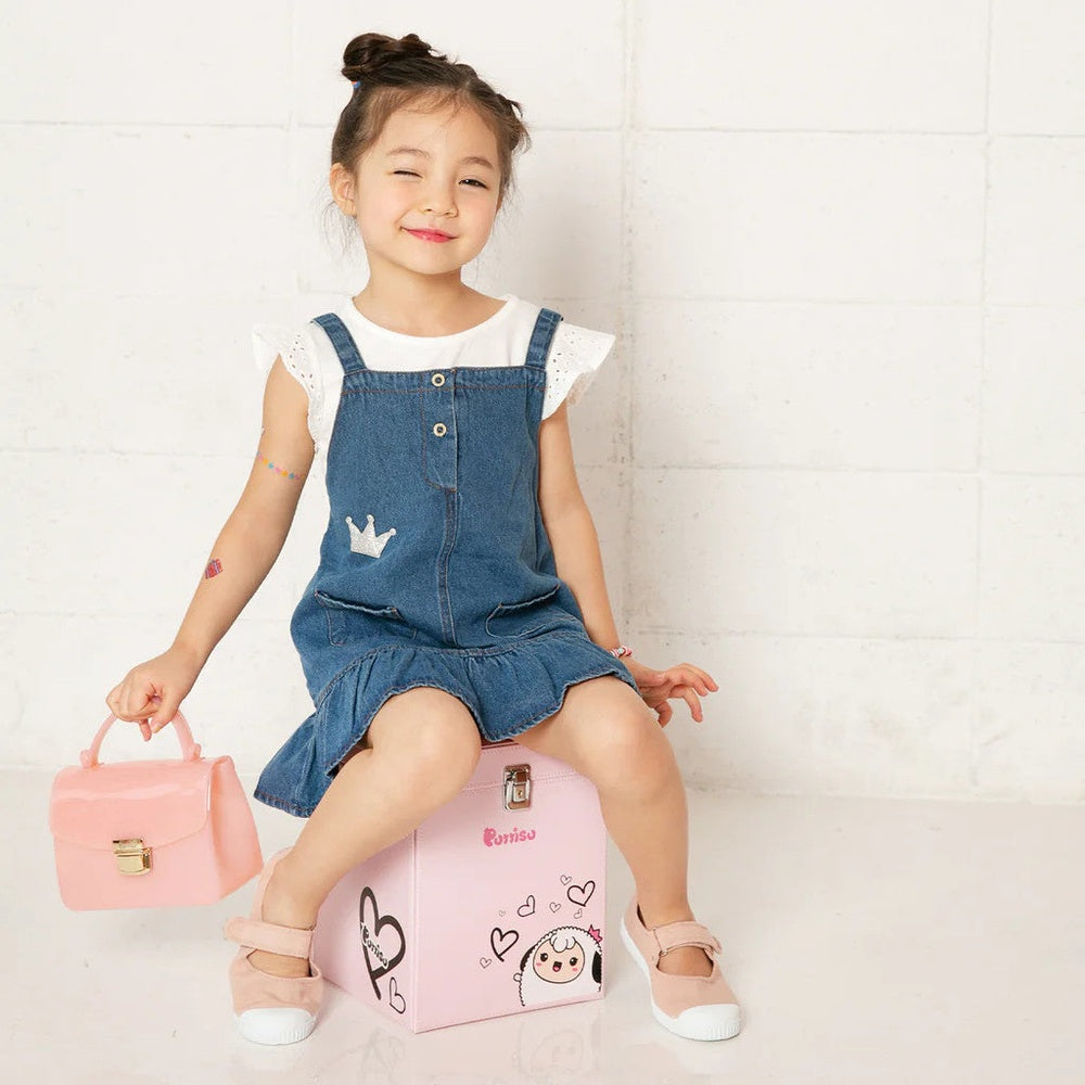 Puttisu Charming Bag pink mini purse with gold clasp carried by a young girl in a denim dress