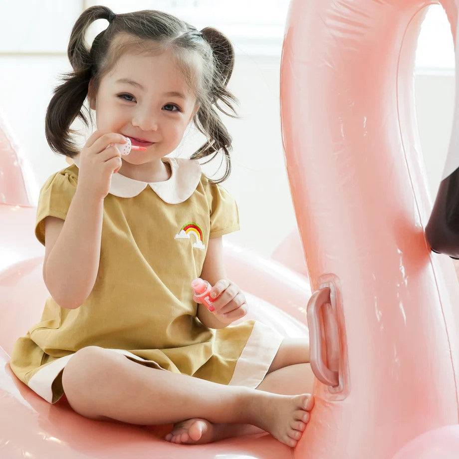 Puttisu Juicy Lip Gloss #01 Red Ruby for kids; pink lip gloss tube held by smiling child