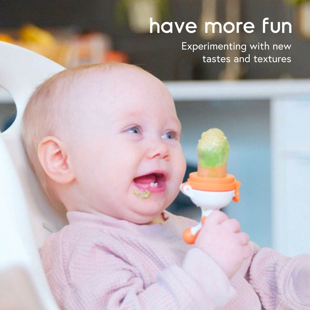 QUARK Fruuti baby fruit feeder pacifier in orange and white, held by a smiling baby