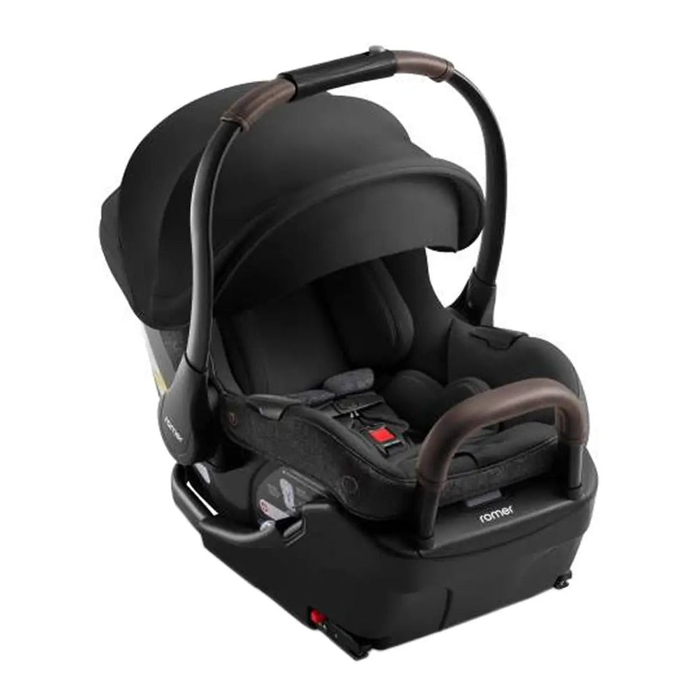 ROMER Juni Infant Car Seat with Versa Base in black, attached to base with handle raised for easy transport.