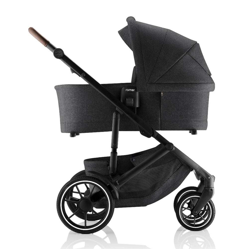 Romer Sera Bassinet for Tura Stroller in dark gray, attached to a sleek black frame with large wheels.
