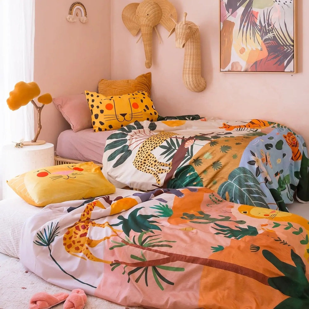 Rookie Humans Kids Bedding Set in the Savanna; vibrant jungle print with leopard and tiger motifs, spread across a bed with a yellow pillow.