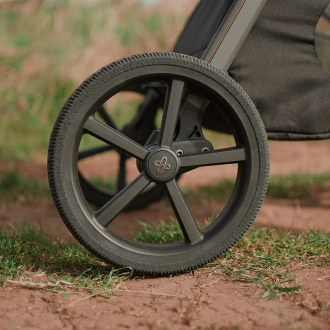 Close-up of a Cove 2 stroller rear wheel on an outdoor path.