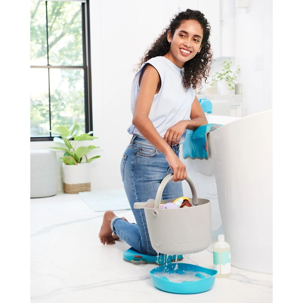 Skip Hop Moby Bathtub Elbow Rest attached to tub edge with blue padding, providing comfortable elbow support while kneeling.