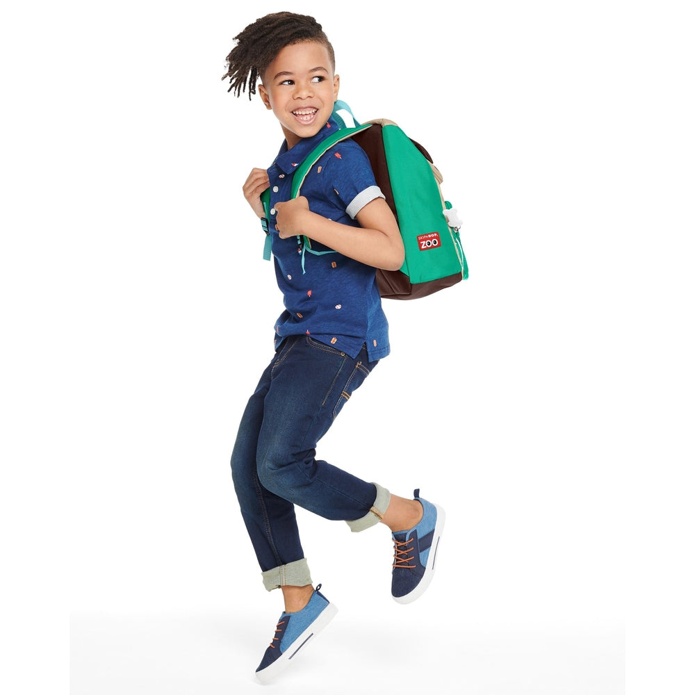 Skip Hop Zoo big kid backpack pug in teal green and brown worn by smiling child