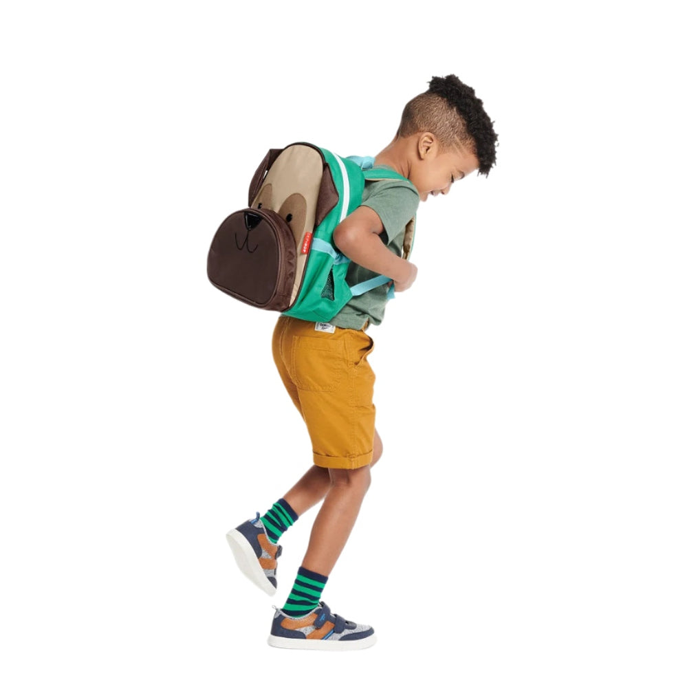 Skip Hop Zoo Little Kid Backpack Pug in brown beige with green straps, worn by a child