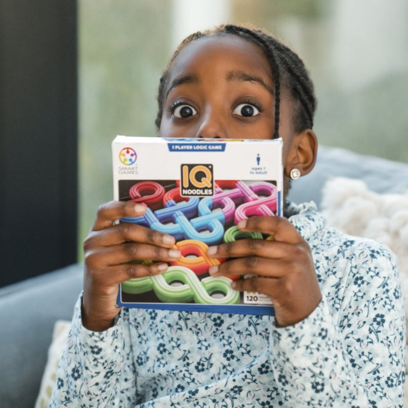 IQ Noodles puzzle box by Smart Games with colorful interlocking noodles held by a child