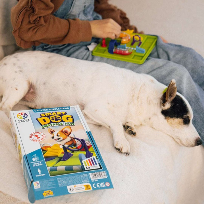 Smart Dog Obstacle Run by SMART GAMES; colorful puzzle pieces on a green board next to a sleeping white dog