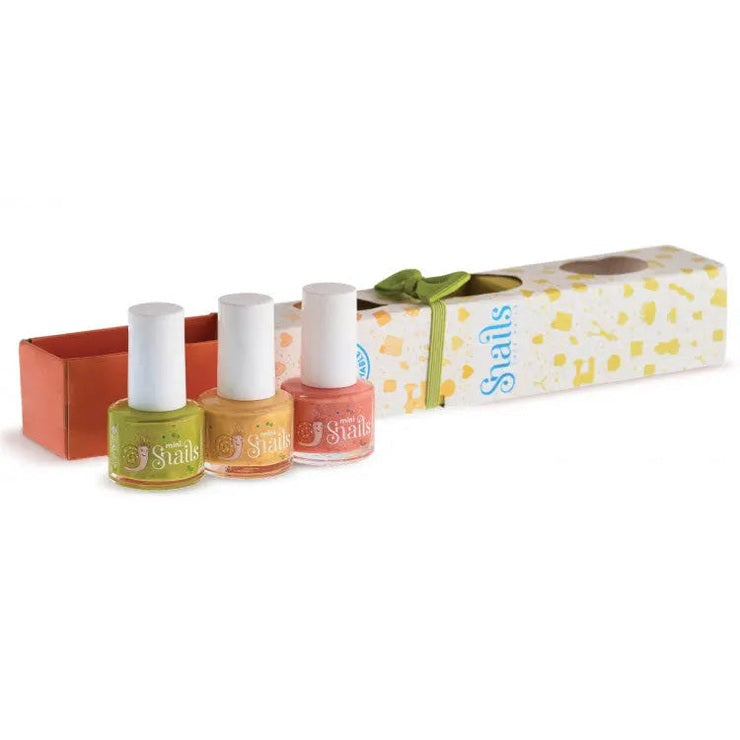 Snail Mini 3 Pack nail polishes in green, orange, pink; three bottles stand beside a patterned gift box tied with a green ribbon.