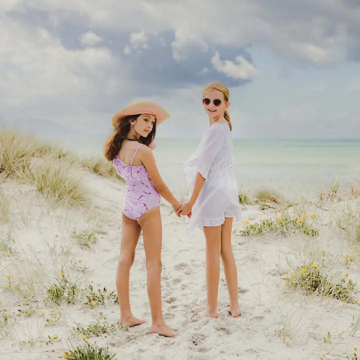 Snapper Rock White Frilled Cover Up for girls; girl in white frilled cover up stands with a friend on a sunny beach.