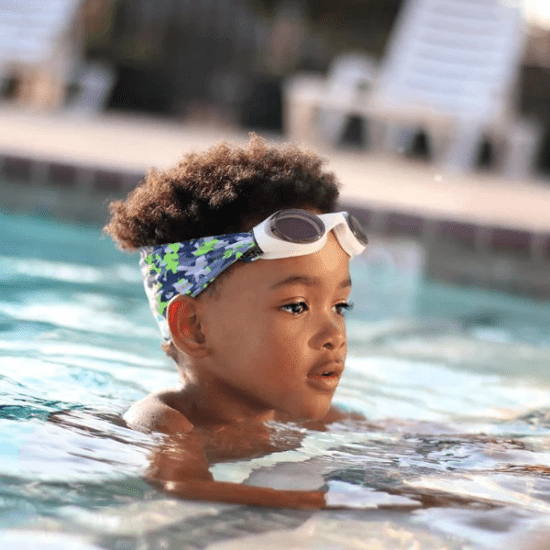 Splash Swim Goggles Camo: child wearing white-framed goggles with blue camouflage strap in pool.