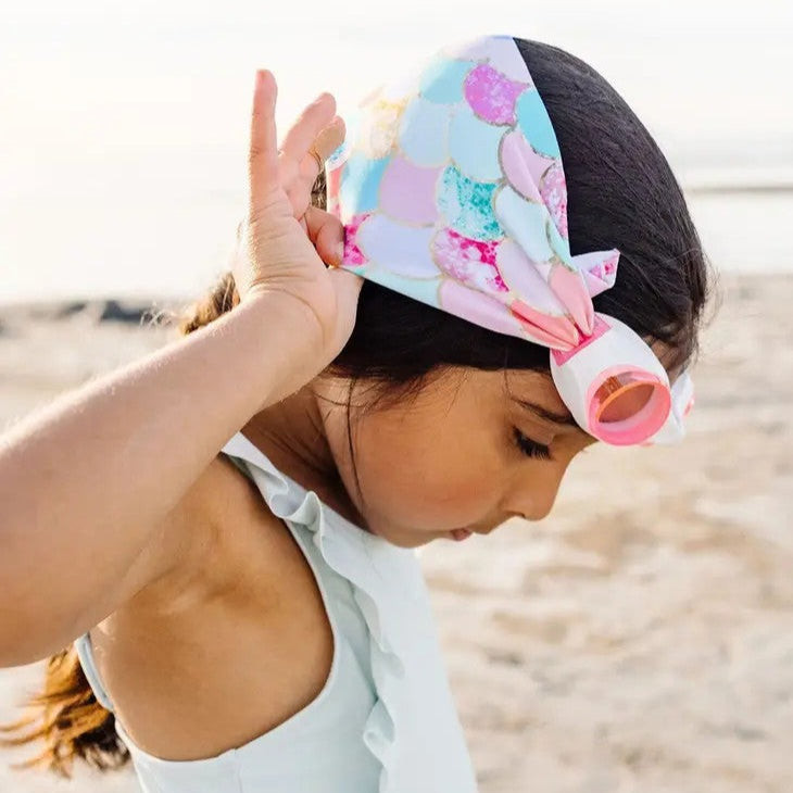 Swim goggles Splash Swim Goggles Mermaid; pastel mermaid-scale print worn by girl on the beach
