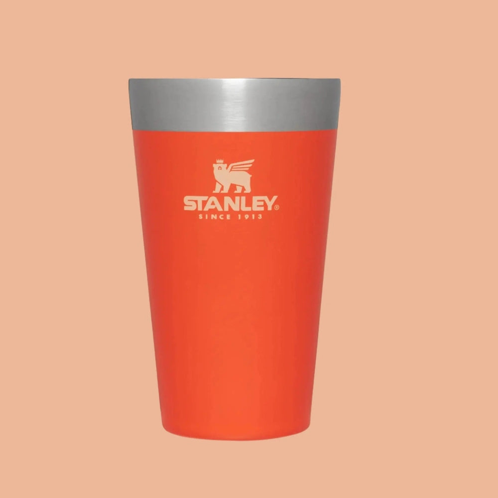 Stanley Adventure Stacking Beer Pint 16 oz orange tumbler with silver rim, STANLEY logo visible while standing upright.