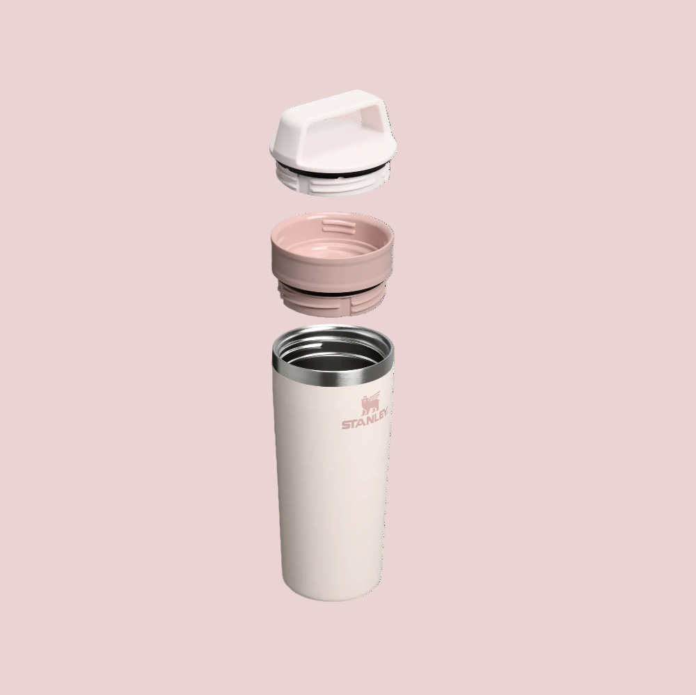 Pink insulated travel mug with a lid on a white background