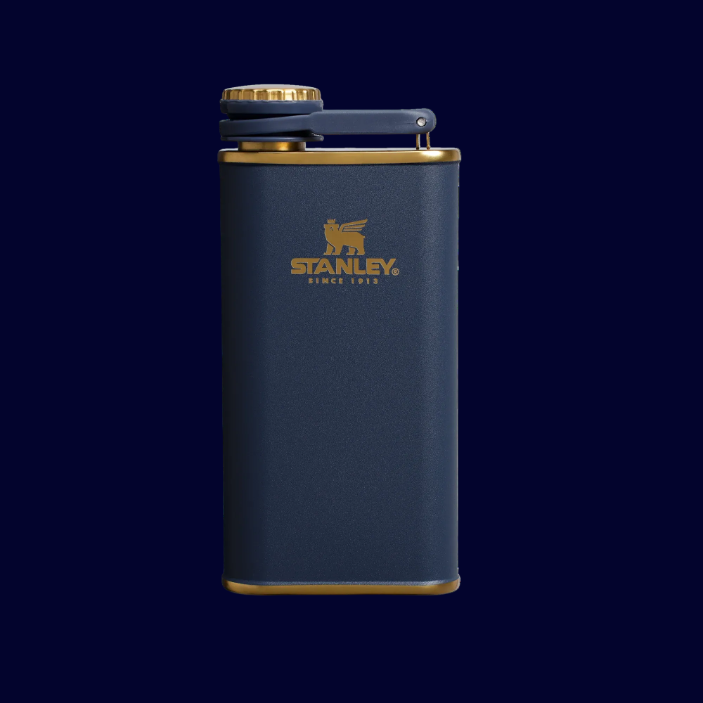Navy blue flask with gold accents on a white background, featuring Stanley logo.