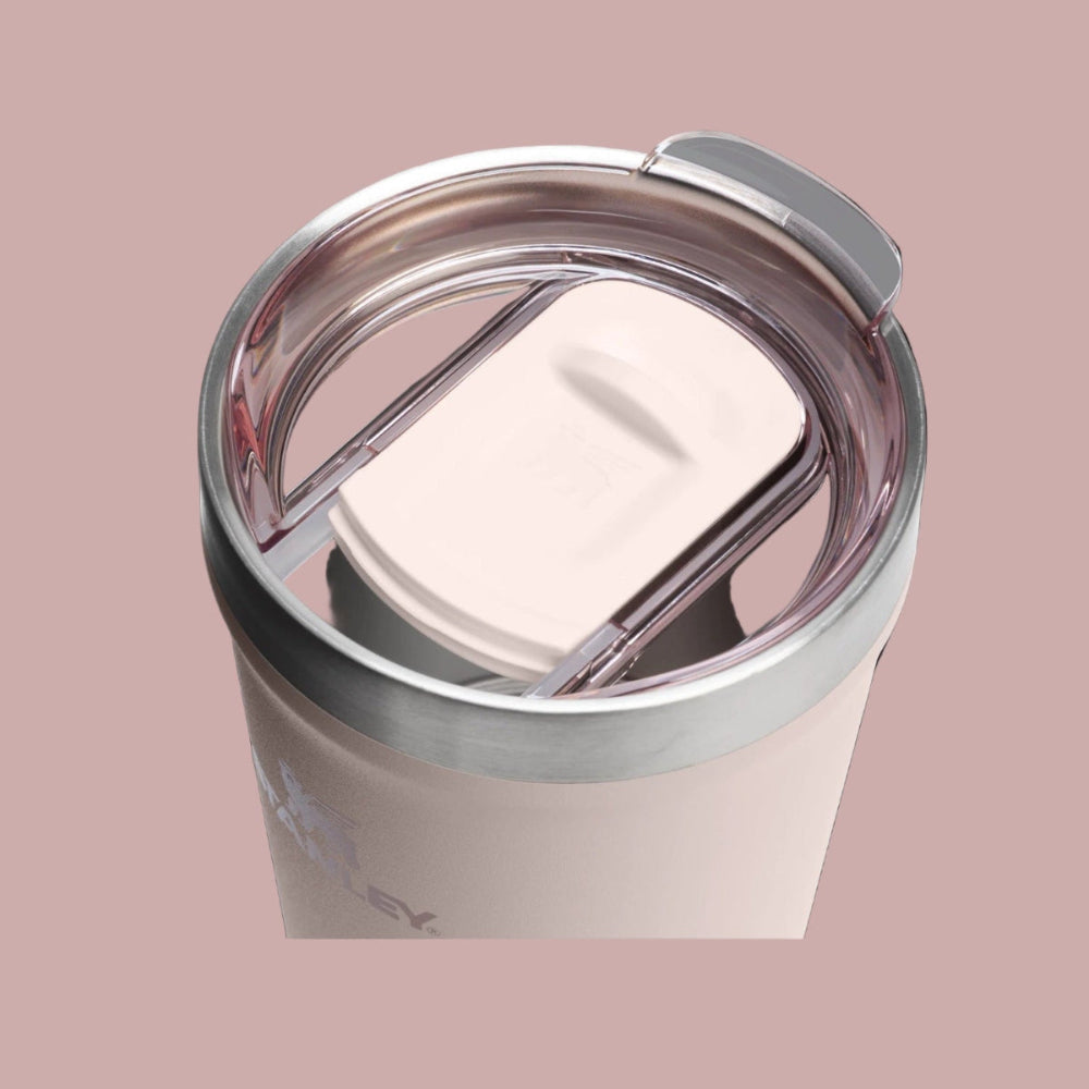 Stanley Everyday Tumbler 16oz in blush pink with stainless rim; user sips through the built-in straw with the clear lid.