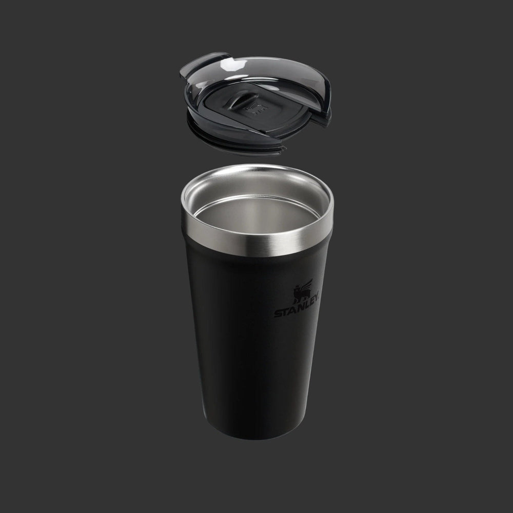 Stanley Everyday Tumbler 16oz in black with stainless rim; lid hovering above as it's about to snap on.