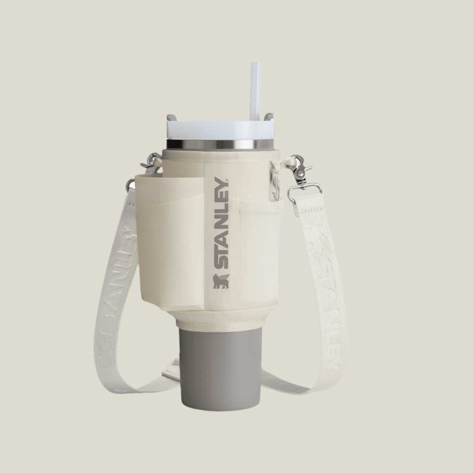 Stanley All Day Quencher Carry-All 40 oz water bottle with cream body and white strap
