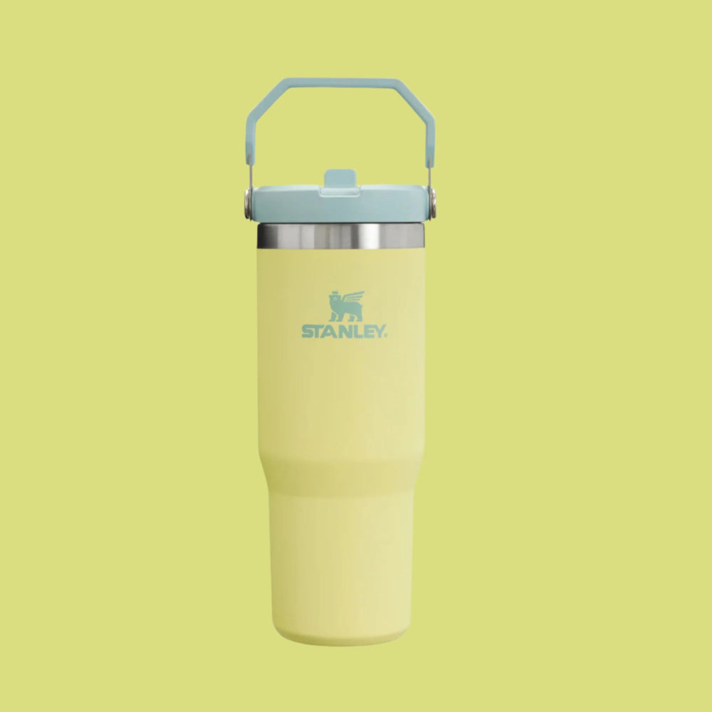 Stanley The Iceflow Flip Straw 2.0 Tumbler 30 oz in yellow, blue lid, held by the built-in carry handle.