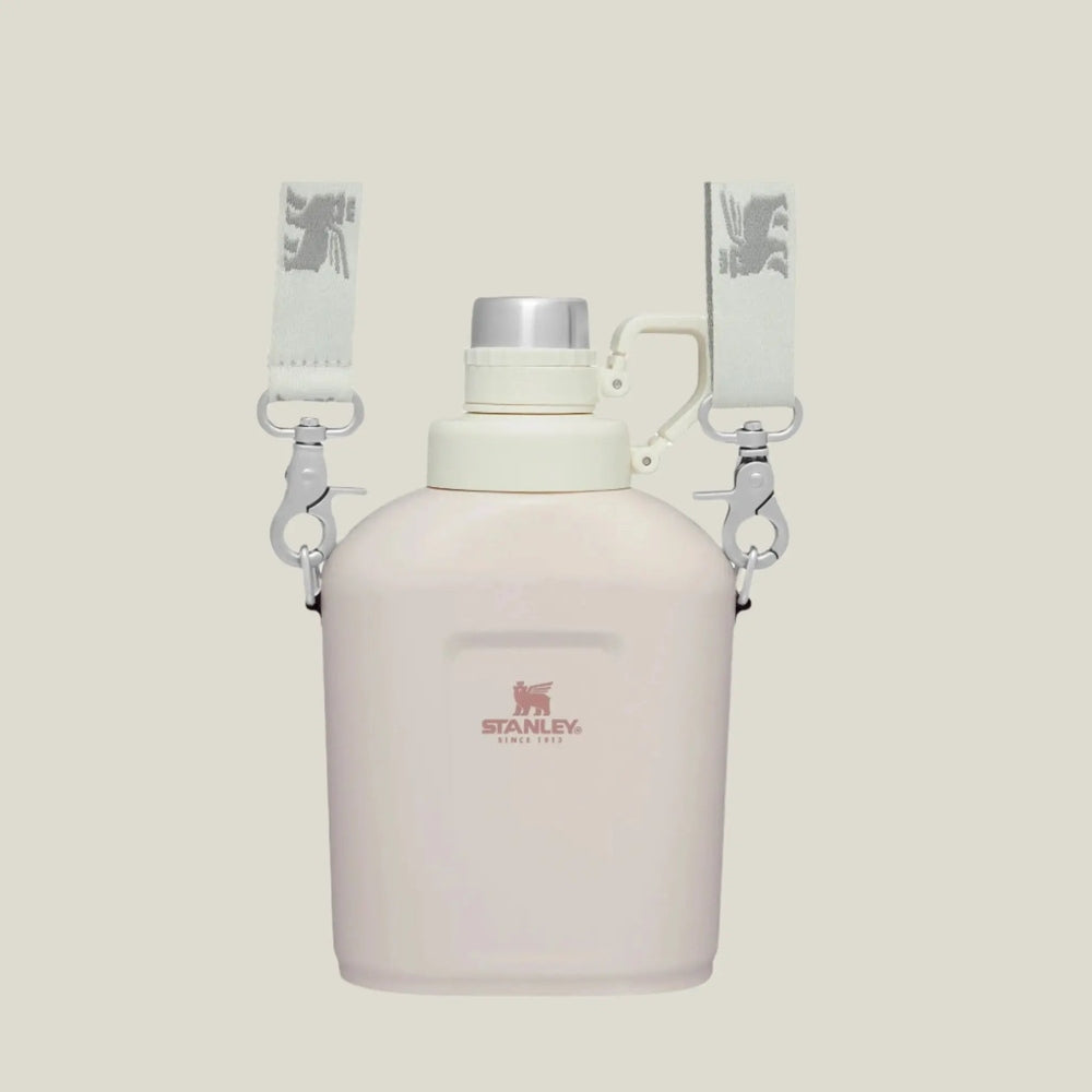 Stanley The Legendary Classic Canteen 1.1 Qt in pale pink with gray straps; clips secure for hands-free carry.