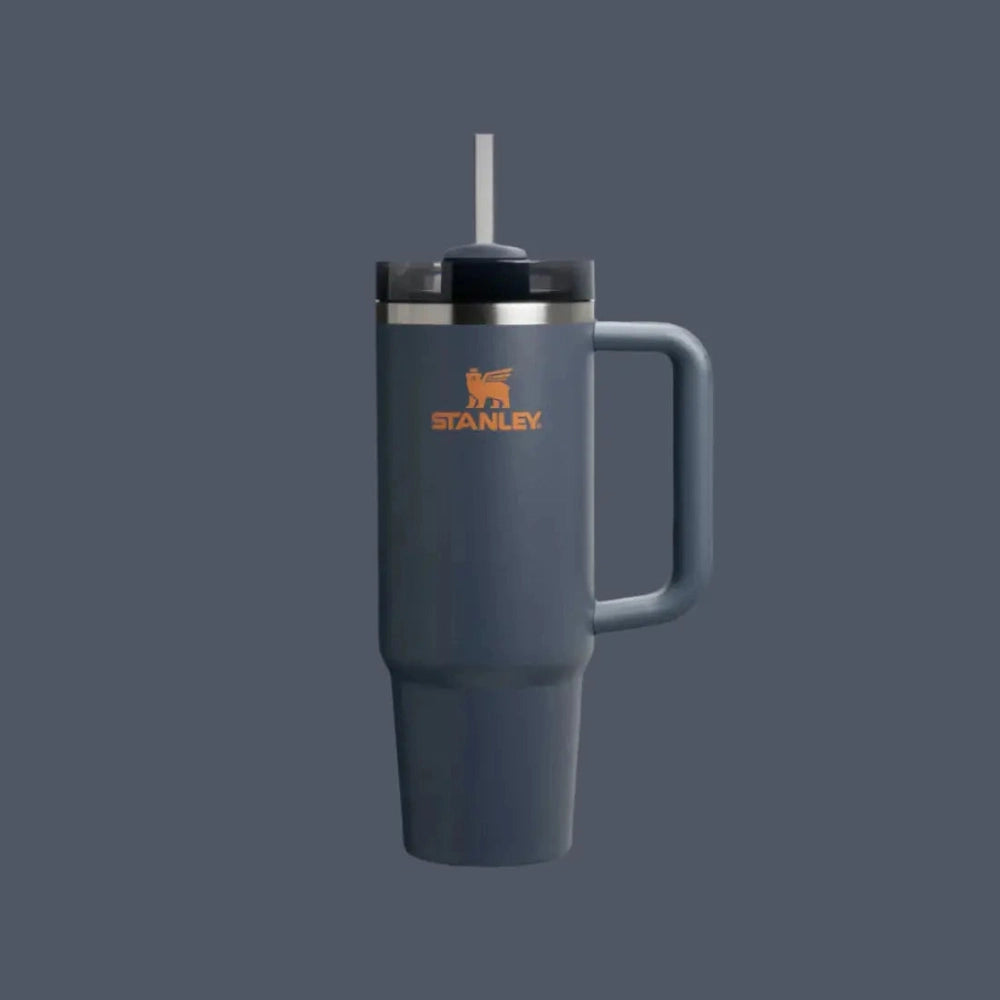 Stanley The Quencher H2.0 Flowstate Tumbler 30 oz in blue with straw extended for sipping.