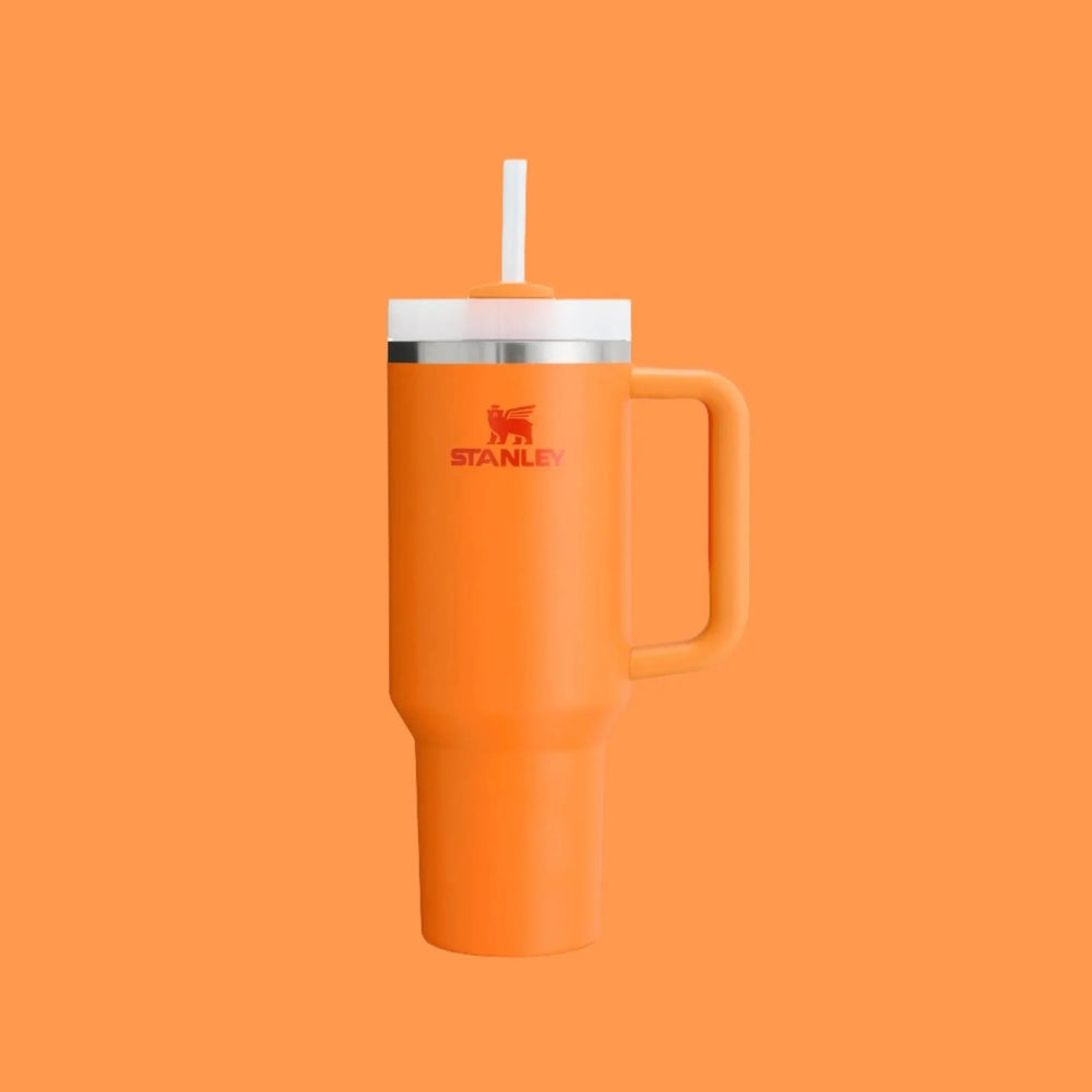 Stanley The Quencher H2.0 Flowstate 40 oz orange tumbler with white lid and straw, orange handle for easy grip.