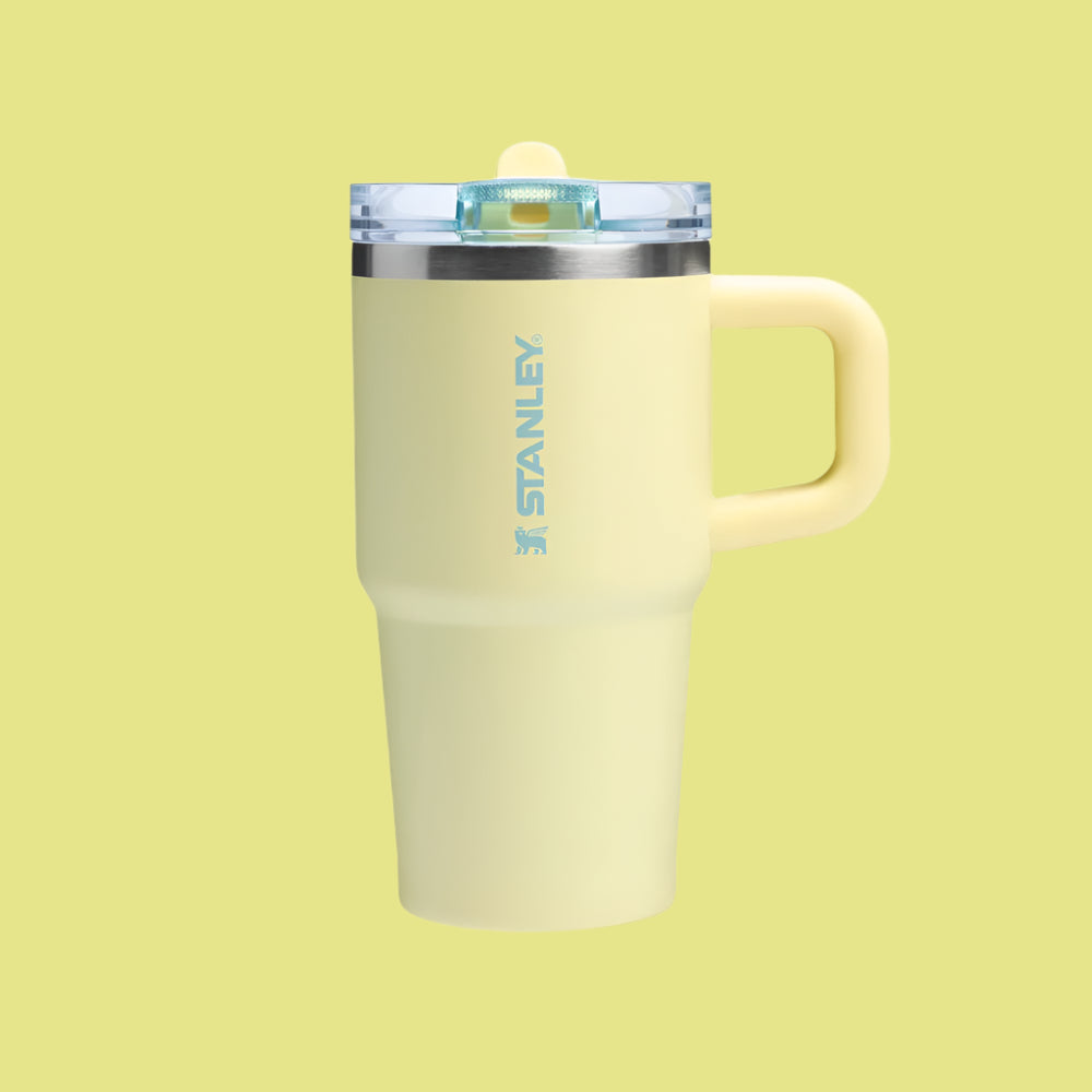 Stanley The Quencher Protour Flip Straw Tumbler 20 oz in pale yellow with clear lid and handle, standing upright with