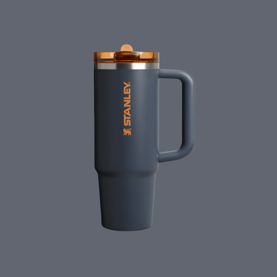 Stanley The Quencher Protour Flip Straw Tumbler 30 oz in blue, orange logo, held by its sturdy handle with flip-top lid.