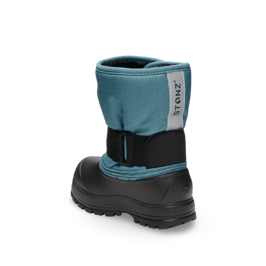 Stonz Trek Toddler Snow Boots Denim, a blue denim boot with a black sole and adjustable strap shown from the back.