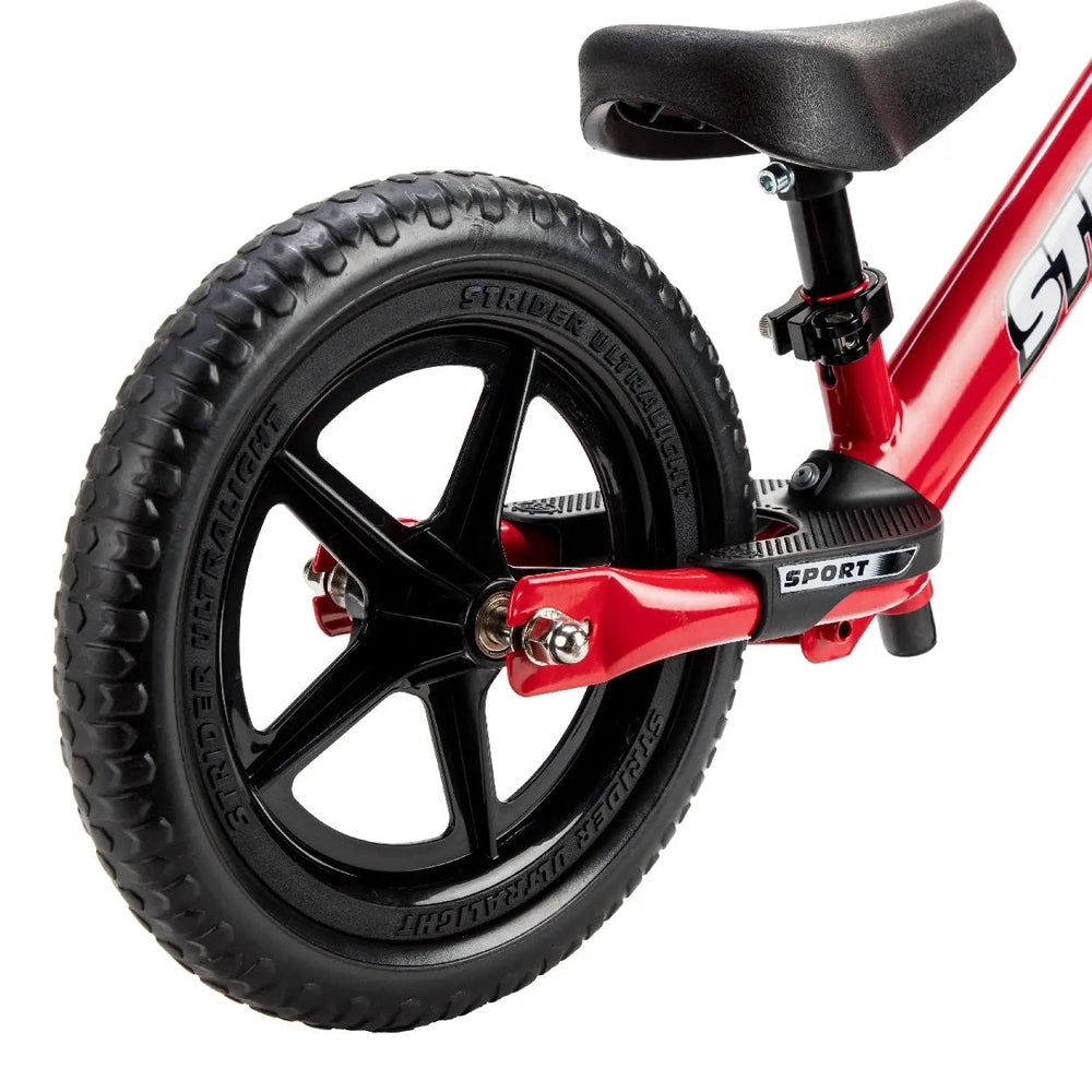 STRIDER 12 Sport balance bike in red with a black 5-spoke rear wheel and adjustable seat post clamp