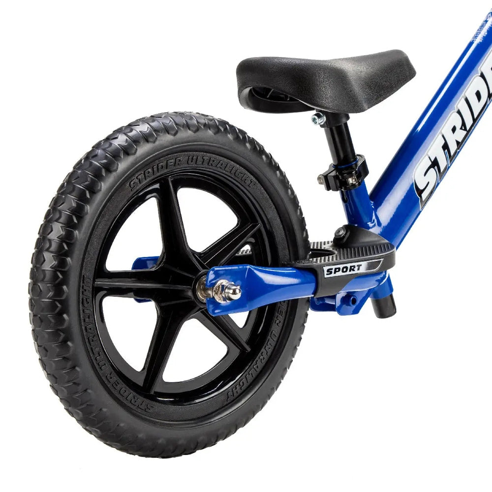 Strider 12 Sport balance bike in blue with a black 5-spoke wheel and visible adjustable seat clamp.