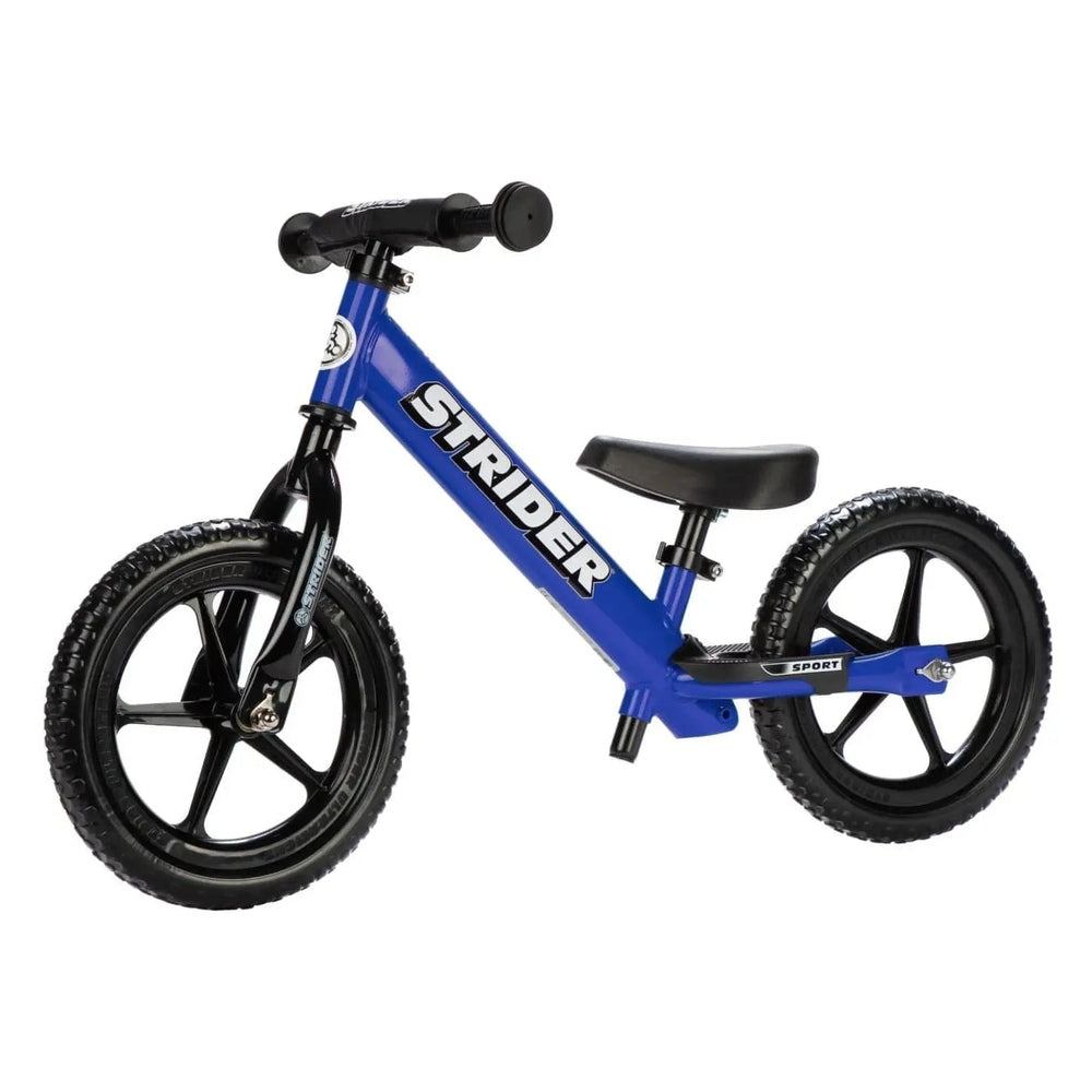 Strider 12 Sport Balance Bike in blue with black wheels and padded saddle, positioned ready to ride.